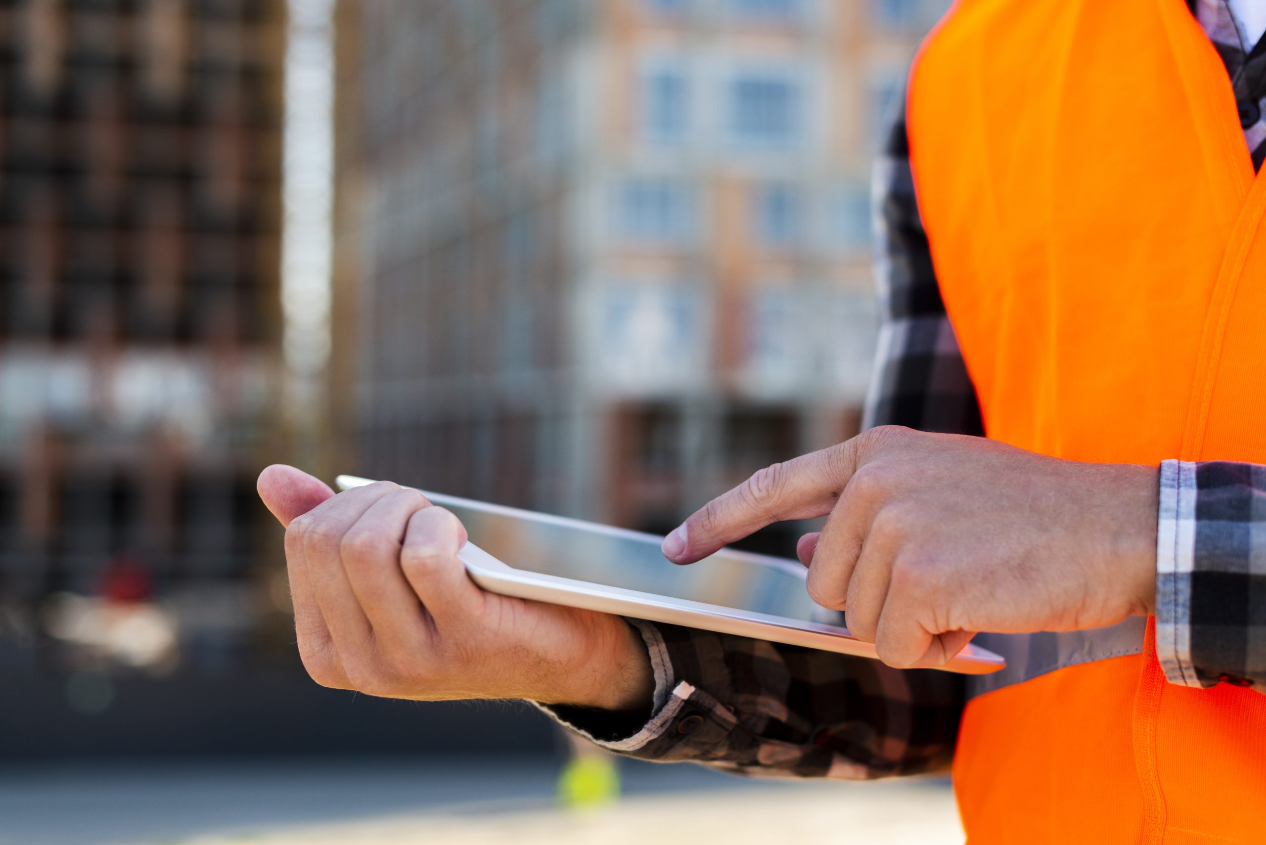 Health and safety inspector using tablet for construction management