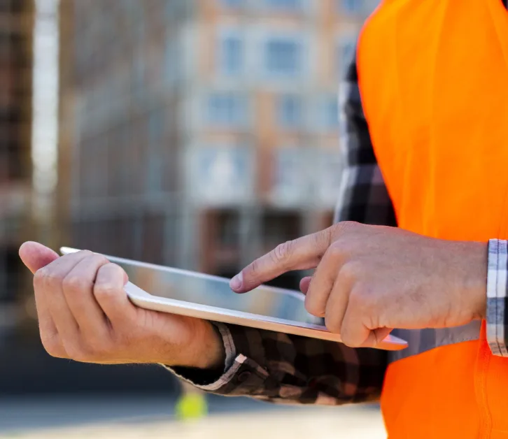 Engineer on site checking project data on a tablet